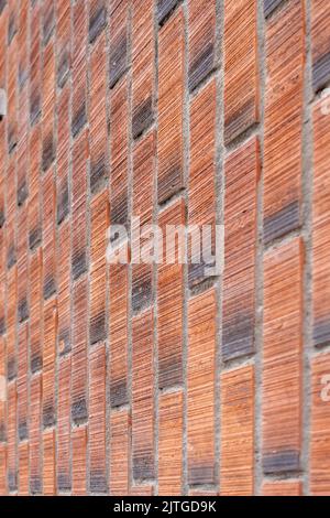 Rough wall of red brown bricks close-up. Vertical masonry Stock Photo