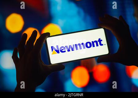 In this photo illustration, the Newmont Corporation logo is displayed on a smartphone screen. Stock Photo