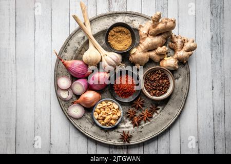 Ingredients for Asian dish arranged on metal plate (garlic, ginger, shallot, chili, star anise) Stock Photo