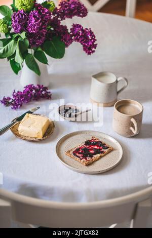 Crispbread with butter and jam and coffee with milk served for breakfast Stock Photo