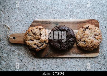 variety of 3 cookies, placed on a wooden plate, on a grey background Stock Photo