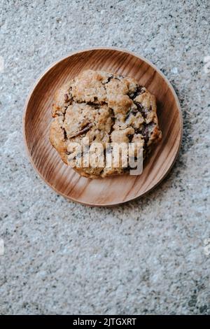 a cookie on a small wooden plate, on a grey textured background Stock Photo