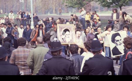 April 30, 1980, London, United Kingdom: Iranian supporters carrying a large protest banner march in London during the six-day siege of the Iranian Embassy. From 30 April to 5 May 1980, a group of six armed Iranian dissidents, opposed to Ayatollah Khomeini, the religious leader who came to power in 1979, took over the Iranian embassy on Prince's Gate in South Kensington, London. The Iranian group took 21 hostages two of whom were killed. Near to the scene of the siege, supporters of Khomeini made their views known with a protest. The dramatic six-day siege ended when elite British SAS troops st Stock Photo