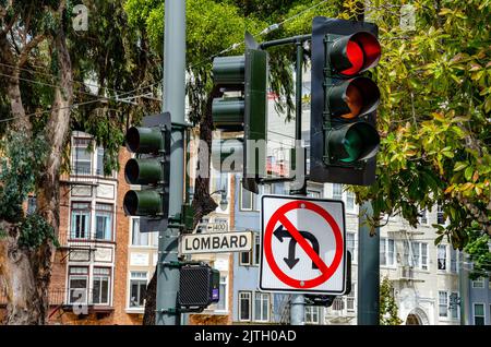 A street sign at a set of traffic lights on Lombard Street in San Francisco, California stating that there is no left turn or u-turn allowed Stock Photo