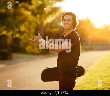 Come skate with me. a young skater outside on a sunny day. Stock Photo