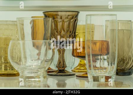 Closeup of assortment of yellow, brown ,white glasses on a shelf Stock Photo