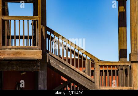 Wooden stairs and landings with rails in bright daylight against a blue sky with room for copy Stock Photo