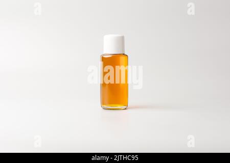 small oil bottle with white cap, mock-up template, isolated on gray background Stock Photo