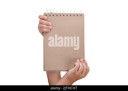 Notepad isolated on white background. Brown notepad made from recycled paper on a white background in the hands of a child Stock Photo