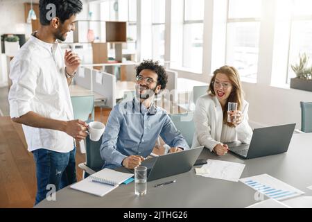 Group of happy coworkers working together analyzing the charts in modern office Stock Photo