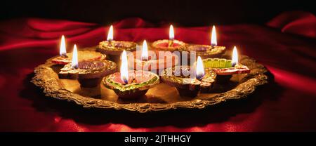 Happy Diwali. Diya oil lamps lit at Deepavali celebration. Hindu Festival of lights, close up view Stock Photo