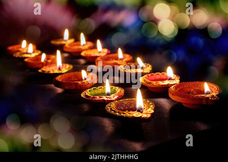 Diwali. Deepavali Hindu festival of lights. Clay diya candle. Oil lamp lit on dark bokeh background Stock Photo