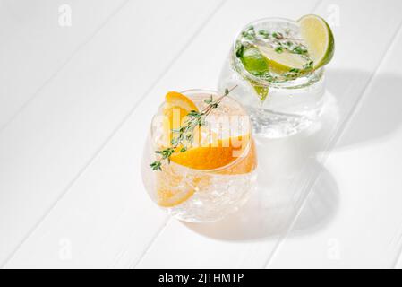 Set of different citrus lemonades with orange and lime on a light background. Tough sunshine. Flashy food Stock Photo