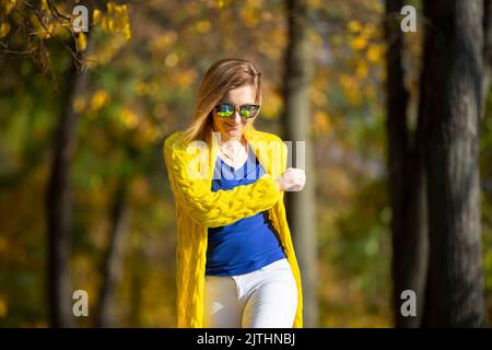 Beautiful woman rejoices on a sunny autumn day, walks in the park Stock Photo