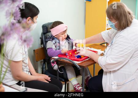 May 31, 2021 Belarus, Gomil, Children's Rehabilitation Center. A psychologist works with a small child with mental retardation. Stock Photo