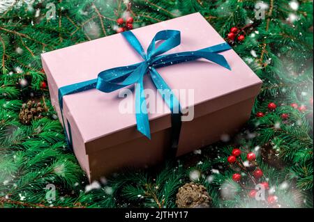Christmas gift. Gift box and Christmas decorations. Christmas composition. Frame made of christmas gifts, dark pine branches on green background. Flat Stock Photo