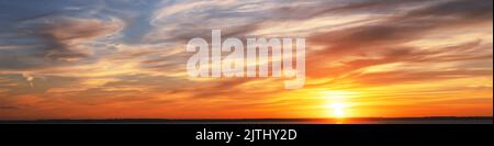 sky sunset. Real amazing panoramic sunrise or sunset sky with gentle colorful clouds. wide panorama. Panorama of orange sunset sky with bright sun Stock Photo