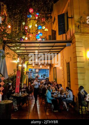 Paper lanterns strung from trees outside a restaurant in Hanoi, Vietnam Stock Photo