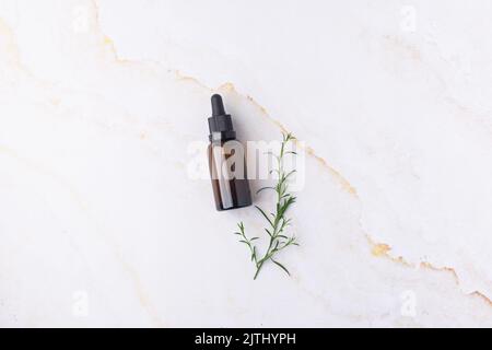 Natural essential oil in the amber bottle concept green leaves cosmetics Stock Photo