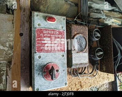 Very old speed controller, meter, switches and wiring in a farm barn. Stock Photo