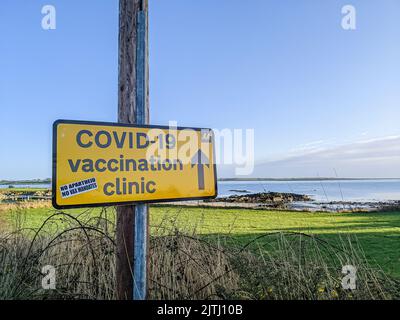 Sticker placed by a protester saying 'No apartheid, no vax mandates' on a sign directing people to COVID-19 vaccinatinon clinic. Stock Photo