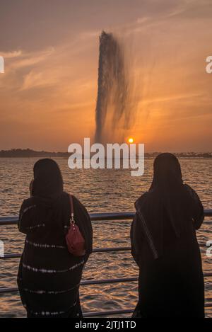 Two arab women observing King Fahd's Fountain at sunset Corniche Park Jeddah Saudi Arabia Stock Photo