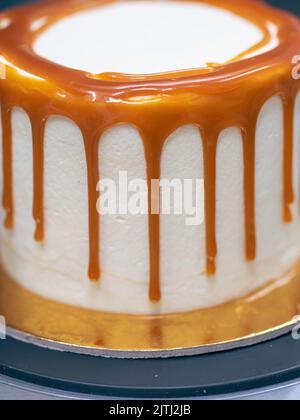 professional baker decorating a chocolate and cream cake with salty caramel Stock Photo