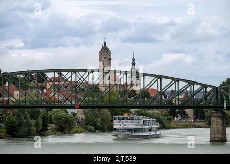 KREMS, AUSTRIA - JULY 13, 2019: View of sightseeing boat and Mautern Bridge over the Danube River with the church towers in the Old Town in background Stock Photo