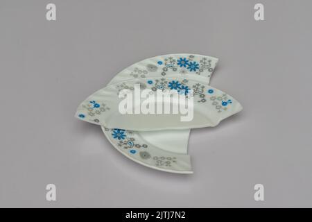 Porcelain plate broken into two pieces isolated white background Stock Photo