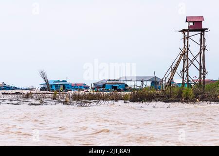 Corrugated iron hut on the top of a tall platform made from bamboo and wooden stilts, Siem Reap river, Cambodia Stock Photo