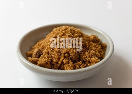 Dark brown sugar on a white background Stock Photo