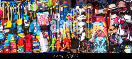 A panoramic image of a colourful display of beach toys and novelties outside a shop in Newquay in Cornwall in the UK. Stock Photo