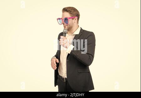 Professional man showman in funny glasses speak to microphone isolated on white, speaker Stock Photo