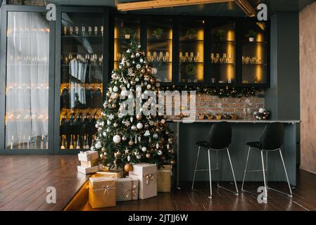 Christmas festive interior of the kitchen and dining room decorated for the New Year's holiday in the loft style in a cozy comfortable house Stock Photo