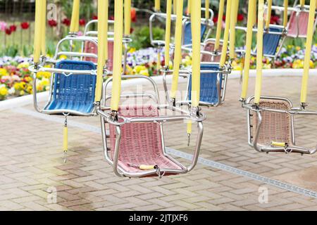 Empty seats of a children's carousel on a chain Stock Photo