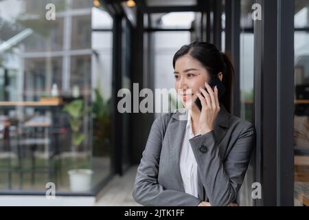 Smiling asian business woman making a phone call Stock Photo