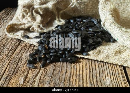 Still life with food on the background of burlap. A pile of seeds on an old board. Natural objects close-up Stock Photo