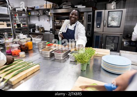 Chef smiling while working in kitchen of restaurant Stock Photo