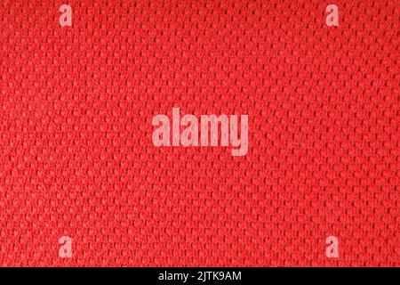Close up background of knitted wool fabric with dots pattern. Bright red color wool knitwear texture. Openwork abstract knitted jersey. Fabric abstrac Stock Photo