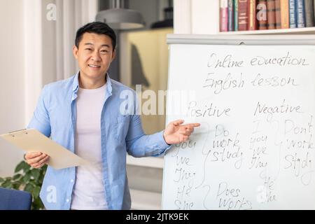 Happy Asian Male Teacher Having English Class In Modern Classroom Stock Photo