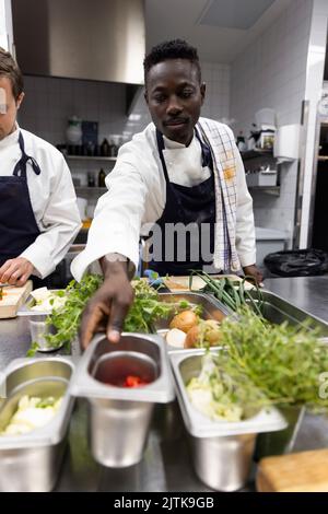 Chefs preparing food in kitchen of restaurant Stock Photo