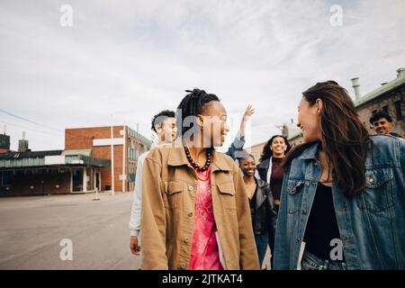 Smiling multiracial young friends enjoying on street in city Stock Photo