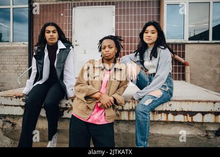 Portrait of confident multiracial young women in front of building Stock Photo