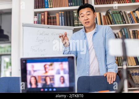 Chinese Teacher Having Distance Class Making Group Video Call Indoors Stock Photo