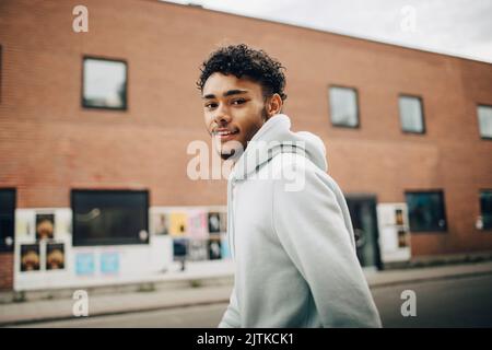 Side view portrait of smiling young man on street Stock Photo
