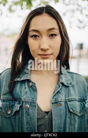 Portrait of confident young woman wearing denim jacket Stock Photo