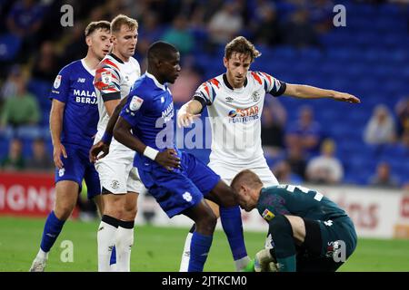 Tom Lockyer of Luton Town (4) reacts as he thinks Niels Nkounkou of Cardiff City (l) fouls Ethan Horvath, the goalkeeper of Luton Town. EFL Skybet championship match, Cardiff city v Luton Town at the Cardiff City Stadium in Cardiff, Wales on Tuesday 30th August 2022. this image may only be used for Editorial purposes. Editorial use only, license required for commercial use. No use in betting, games or a single club/league/player publications. pic by Andrew Orchard/Andrew Orchard sports photography/Alamy Live news Stock Photo