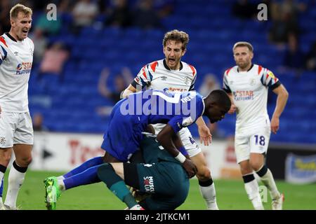 Tom Lockyer of Luton Town (4) reacts as he thinks Niels Nkounkou of Cardiff City (l) fouls Ethan Horvath, the goalkeeper of Luton Town. EFL Skybet championship match, Cardiff city v Luton Town at the Cardiff City Stadium in Cardiff, Wales on Tuesday 30th August 2022. this image may only be used for Editorial purposes. Editorial use only, license required for commercial use. No use in betting, games or a single club/league/player publications. pic by Andrew Orchard/Andrew Orchard sports photography/Alamy Live news Stock Photo