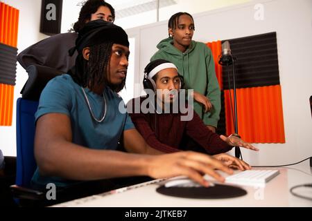 Sound engineers and rappers working together in recording studio Stock Photo