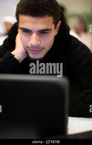 Student using laptop sitting in classroom Stock Photo